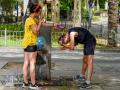 Una joven le hace una foto a un joven mientras le está refrescando la cabeza en Sevilla