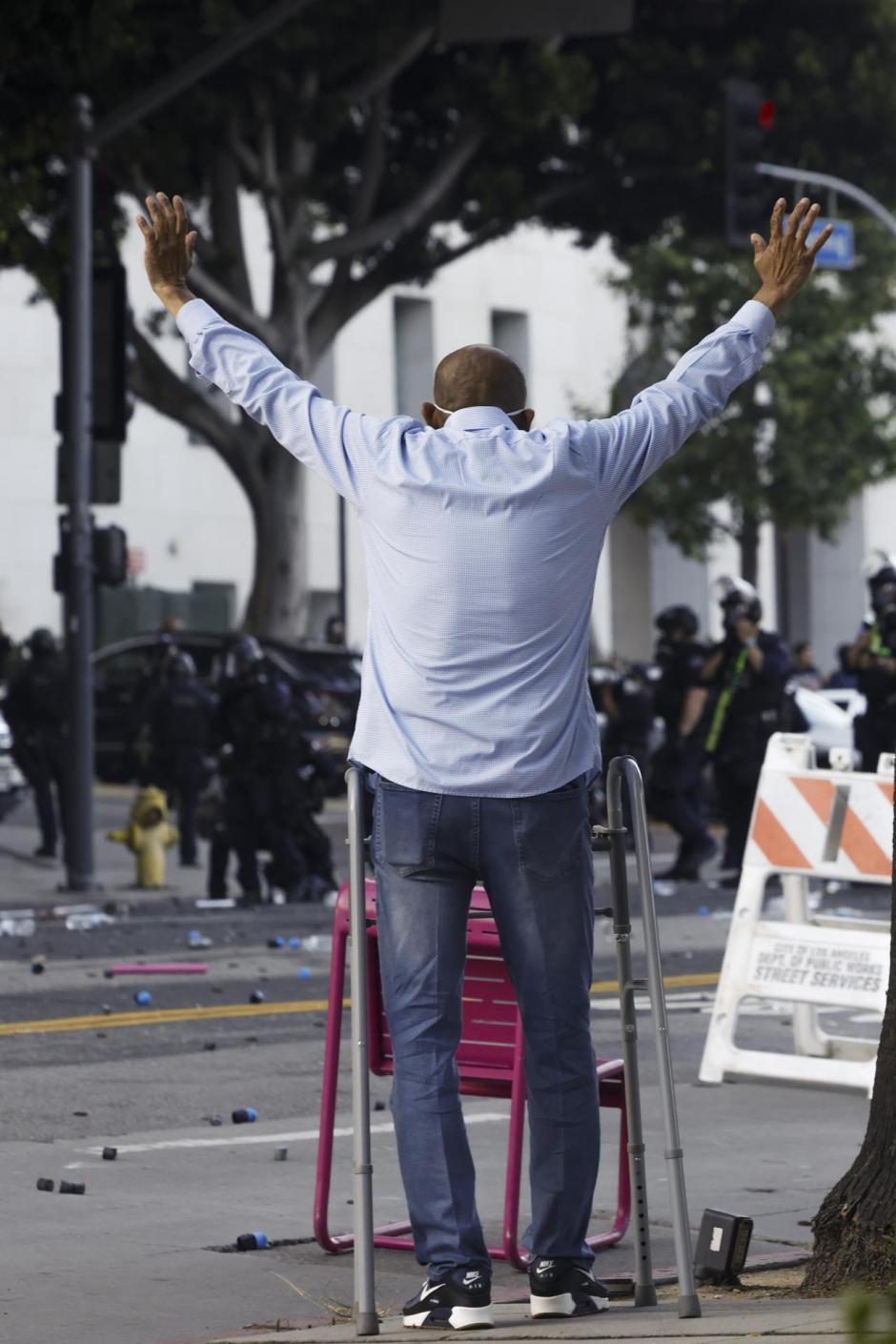 LOS ANGELES (United States), 09/06/2025.- A man raises his hands during protests sparked by immigration raids in Los Angeles, California, USA, 08 June 2025. US President Donald Trump has deployed 2,000 National Guard troops, despite not receiving a request from the state of California for any additional assistance, following large protests against ongoing immigration enforcement raids in the Los Angeles area over the last couple of days. (Protestas) EFE/EPA/CAROLINE BREHMAN